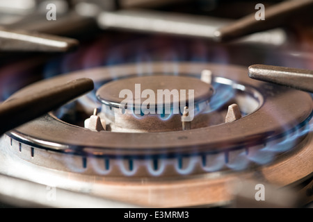 A close up of a blue gas flames burning on a kitchen cooker gas rig or burner Stock Photo