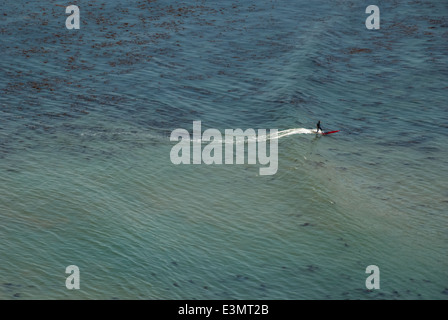 Lone surfer rides a gentle summer swell on a longboard at Bluff Cove in Palos Verdes near Los Angeles, California, USA. Stock Photo