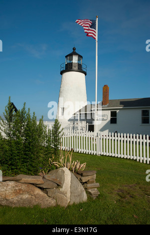 American flag waves in front of the entrance to the Fisherman's Museum next to the Pemaquid Point lighthouse tower. Stock Photo