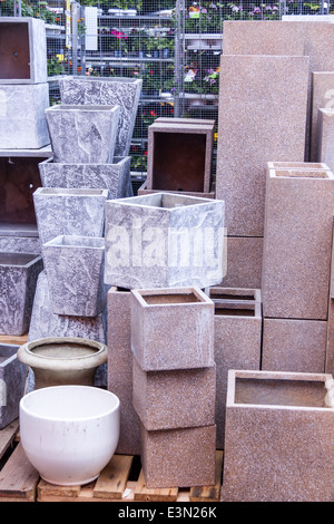 Glazed and unglazed ceramic flower pots in a variety of sizes and colors stacked on wooden pallets outside a pottery, warehouse Stock Photo