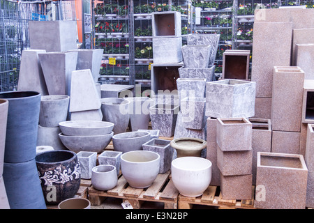 Glazed and unglazed ceramic flower pots in a variety of sizes and colors stacked on wooden pallets outside a pottery, warehouse Stock Photo