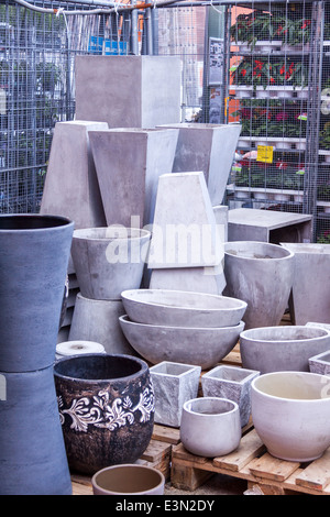 Glazed and unglazed ceramic flower pots in a variety of sizes and colors stacked on wooden pallets outside a pottery, warehouse Stock Photo