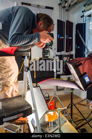 Professional photographer working in a commercial photography studio, including lighting, background and grip gear. Stock Photo