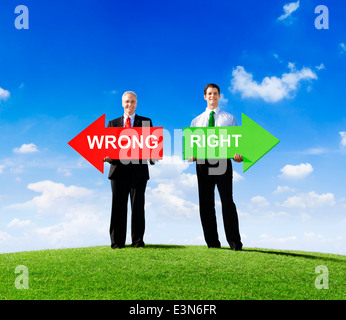 Two Businessmen Holding Contrasting Arrows for Wrong and Right Stock Photo