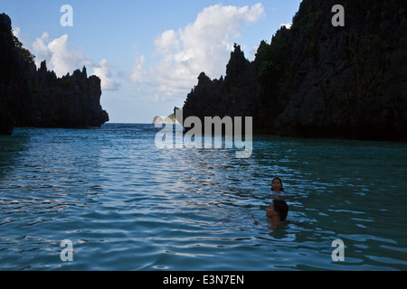 Swimming at a secluded beach on MATINLOC ISLAND near EL NIDO in the BACUIT ARCHIPELAGO - PALAWAN ISLAND, PHILIPPINES Stock Photo