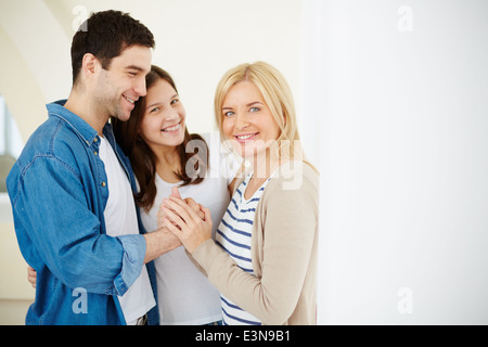 Portrait of happy family of three in isolation Stock Photo