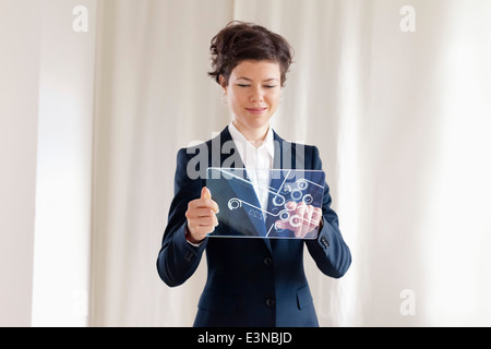 Confident Businesswoman Using Futuristic Digital Tablet Stock Photo