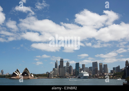 View of Sydney opera house and skyline against cloudy sky, Australia Stock Photo