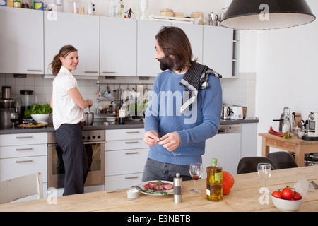 Couple preparing food in kitchen Stock Photo