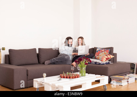 Mid adult couple using laptop in living room Stock Photo