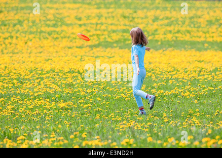 Boy Throwing Frisbee in Meadow of Dandelions Stock Photo