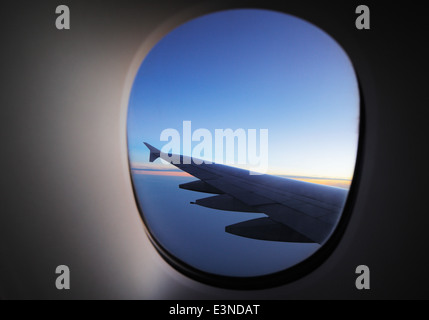 A window view of the wing of a modern luxury jet plane Stock Photo