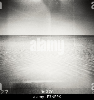 Designed retro photo. Sunny day on the beach. Grain, dust, colors added as vintage effect. Stock Photo