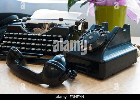 Vintage telephone and typewriter standing on the desk in the office Stock Photo