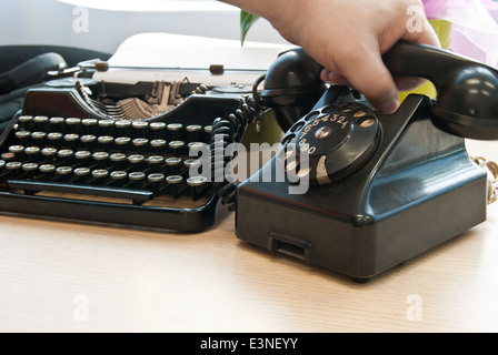 Vintage telephone and typewriter standing on the desk in the office Stock Photo