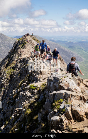 View back along Crib Goch ridge scramble with hikers scrambling at start of Snowdon Horseshoe in mountains of Snowdonia Wales UK Stock Photo