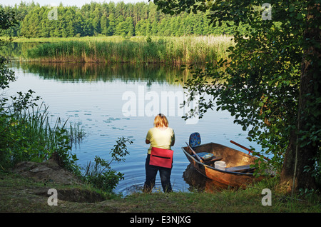 Travel on the silent forest river in the summer. The boat is moored to the river bank. Stock Photo