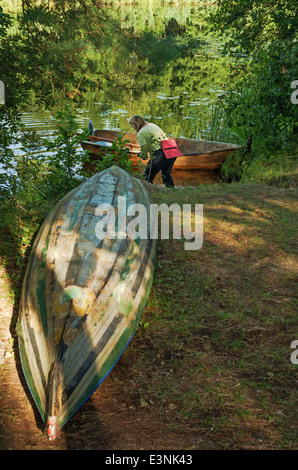 Travel on the silent forest river in the summer. The boat is moored to the river bank. Canoe on river coast. Stock Photo