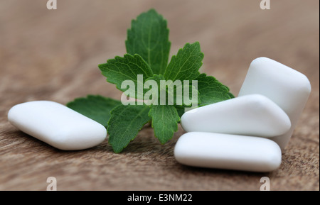 Chewing gum with green stevia on wooden surface Stock Photo