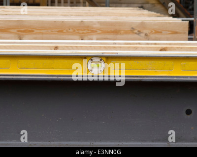 self building house, builder checking level of steel lintel with long spirit level Stock Photo