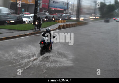 Recife, Brazil. 26th June, 2014. A man rides a scooter on a flooded street in Recife, Brazil, 26 June 2014. Photo: Marcus Brandt/dpa/Alamy Live News Stock Photo