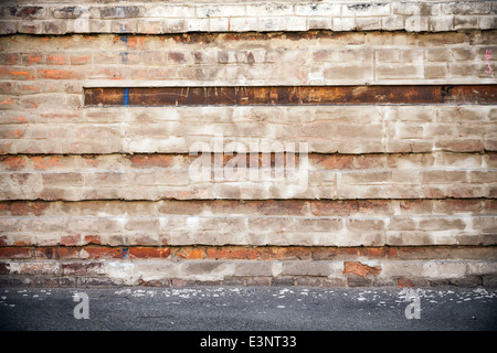Abstract urban background. Old brick wall and asphalt Stock Photo