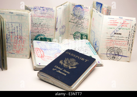 Various American passports open to reveal multiple entry and exit stamps and visas from Middle Eastern countries. Stock Photo