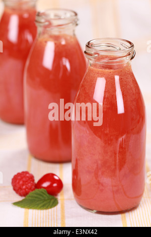 Freshly squeezed juice from red fruits in bottles Stock Photo