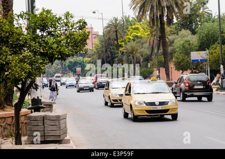 Newer, cleaner Dacia beige taxis on the roads around Marrakech, Morocco.  Traditional petit taxis in Morocco tend to be very old Mercedes Benz cars. Stock Photo