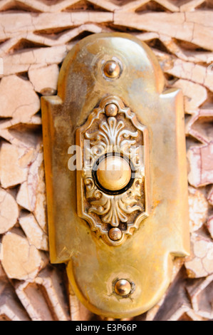 Brass electric doorbell button on a door in Marrakech, Morocco Stock Photo