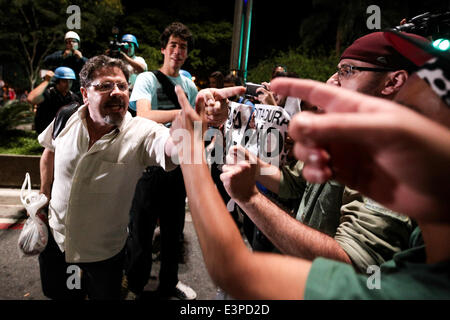 Sao Paulo, Brazil. 26th June, 2014. A man argues with the demonstrators during their protest against the arrest of two people during the demonstration against the FIFA 2014 World Cup in the Paulista Avenue in Sao Paulo, Brazil. The people gathered beneath the Museum of Art of Sao Paulo before proceeding to the Paulista Avenue but they are prevented from marching through the city by the police. Credit:  Tiago Mazza Chiaravalloti/Pacific Press/Alamy Live News Stock Photo
