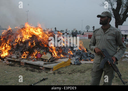 Lahore. 26th June, 2014. A Pakistani paramilitary soldier stands guard beside a burning pile of drugs in eastern Pakistan's Lahore June 26, 2014, on International Day against Drug Abuse and Illicit Trafficking. Credit:  Sajjad/Xinhua/Alamy Live News Stock Photo