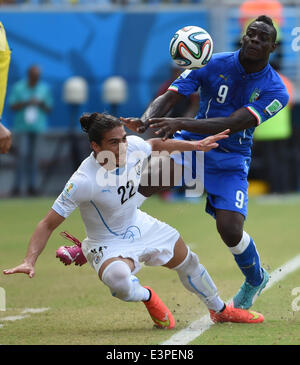 Natal, Brazil. 24th June, 2014. Italy's Mario Balotelli vies with Uruguay's Martin Caceres during a Group D match between Italy and Uruguay of 2014 FIFA World Cup at the Estadio das Dunas Stadium in Natal, Brazil, June 24, 2014. © Guo Yong/Xinhua/Alamy Live News Stock Photo