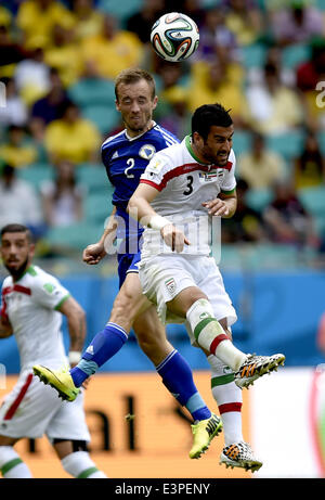 Salvador, Brazil. 24th June, 2014. Bosnia And Herzegovina's Avdija Vrsaljevic competes for a header with Iran's Ehsan Hajsafi during a Group F match between Bosnia And Herzegovina and Iran of 2014 FIFA World Cup at the Arena Fonte Nova Stadium in Salvador, Brazil, June 24, 2014. © Yang Lei/Xinhua/Alamy Live News Stock Photo