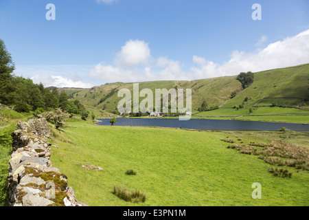 Watendlath Tarn, Borrowdale, Lake District, UK in summer with view of farmhouse, fells and blue sky with white fluffy clouds Stock Photo
