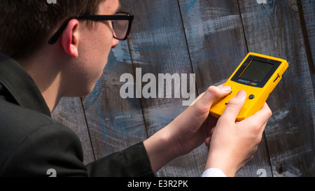 School Teenager Playing on a Nintendo Game Boy Color. Stock Photo