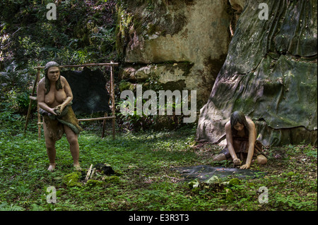 Prehistoric Neanderthal women working at open air dwelling with shelter made of animal hides from the Magdalenian period Stock Photo