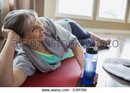 Smiling woman laying on yoga mat