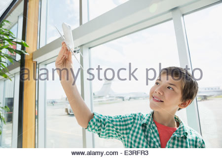 Boy playing with toy airplane in airport