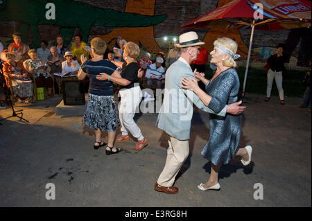 Warsaw, Poland. 27th June, 2014. Friday night is party time, even for residents of a retirement home in the old, eastern part of Warsaw, the capital of Poland. Accompanied by young musicians, the informal choir of golden agers presented a number of traditional urban folklore songs. After sunset, fleet-footed blue-hairs filled the open-air dance floor at Brzeska Street. Credit:  Henryk Kotowski/Alamy Live News Stock Photo