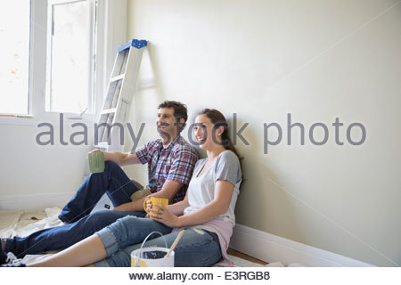 Happy couple drinking coffee on paint drop cloth