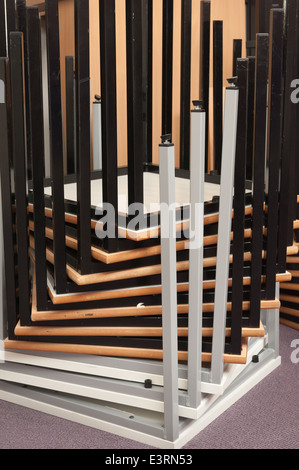 Inverted upside down stacked metal tables deck legs making a pattern of bars spiraling upwards at corners Stock Photo