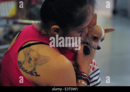 Manila, Philippine. 28th June, 2014. MANILA, Philippines - A woman with a portrait of her dog tattooed on her back prepares to have her dog's photo taken as hundreds of pet lovers join a Dog and Cat Expo held at a Convention Center in Pasay city, south of Manila on 28 June 2014. Now on its third year, the Pet Express Dog and Cat EXPO attracts thousands of dog and cat lovers of all ages as they hold this 2-day event, with various activities for the animals and their owners to participate in. The event aims to give the canine and feline community a venue to meet like-minded people and to learn Stock Photo