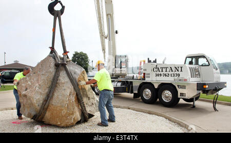 Le Claire, IOWA, USA. 28th June, 2014. Crews with Superior Seawalls and Docks work to put the The Scott County Freedom Rock in place on the river front in LeClaire, Iowa on Saturday, June 28, 2014. The original Freedom Rock is a large (approx. 60 ton) boulder located in rural Iowa that is repainted every year with a different Thank You for our nations Veterans to honor their service to our country. The artist, Ray ''Bubba'' Sorensen II, was inspired by the movie Saving Private Ryan, as well as, wanting to give Veterans a unique recognition on Memorial Day. With 99 counties in Iowa presently Stock Photo