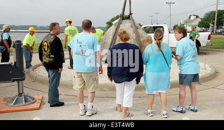 Le Claire, IOWA, USA. 28th June, 2014. Local residents watch as crews with Superior Seawalls and Docks work to put the The Scott County Freedom Rock in place on the river front in LeClaire, Iowa on Saturday, June 28, 2014. The original Freedom Rock is a large (approx. 60 ton) boulder located in rural Iowa that is repainted every year with a different Thank You for our nations Veterans to honor their service to our country. The artist, Ray ''Bubba'' Sorensen II, was inspired by the movie Saving Private Ryan, as well as, wanting to give Veterans a unique recognition on Memorial Day. With 99 co Stock Photo