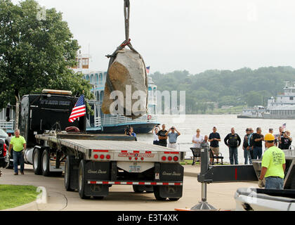 Le Claire, IOWA, USA. 28th June, 2014. Local residents watch as crews with Superior Seawalls and Docks work to put the The Scott County Freedom Rock in place on the river front in LeClaire, Iowa on Saturday, June 28, 2014. The original Freedom Rock is a large (approx. 60 ton) boulder located in rural Iowa that is repainted every year with a different Thank You for our nations Veterans to honor their service to our country. The artist, Ray ''Bubba'' Sorensen II, was inspired by the movie Saving Private Ryan, as well as, wanting to give Veterans a unique recognition on Memorial Day. With 99 co Stock Photo