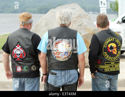 Le Claire, IOWA, USA. 28th June, 2014. Three Veterans watch as the Scott County Freedom Rock arrived in Le Claire, Iowa on Saturday, June 28, 2014. The original Freedom Rock is a large (approx. 60 ton) boulder located in rural Iowa that is repainted every year with a different Thank You for our nations Veterans to honor their service to our country. The artist, Ray ''Bubba'' Sorensen II, was inspired by the movie Saving Private Ryan, as well as, wanting to give Veterans a unique recognition on Memorial Day. With 99 counties in Iowa presently there are 17 completed Freedom Rocks in other Iowa Stock Photo