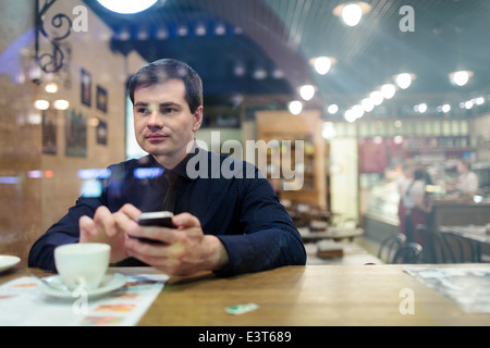 Man at the table texting Stock Photo