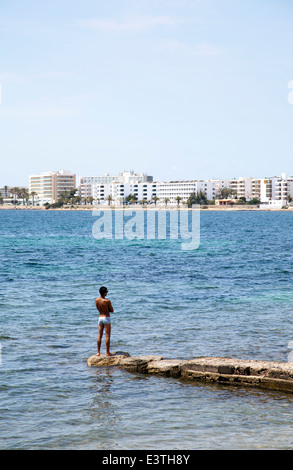 Man Standing on Groyne at Figueretas Beach in Ibiza - Spain Stock Photo