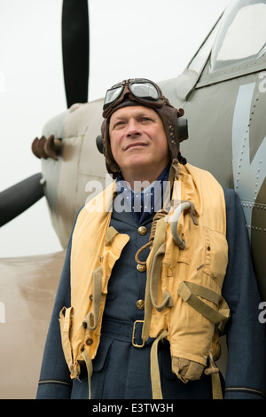 WW2 RAF pilot wearing his Mae West life jacket, stands at the ready beside his Spitfire fighter aircraft. Stock Photo
